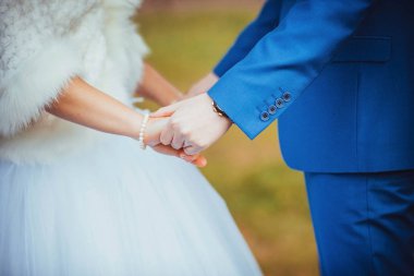 Gelin ve damat el ele tutuşuyorlar.