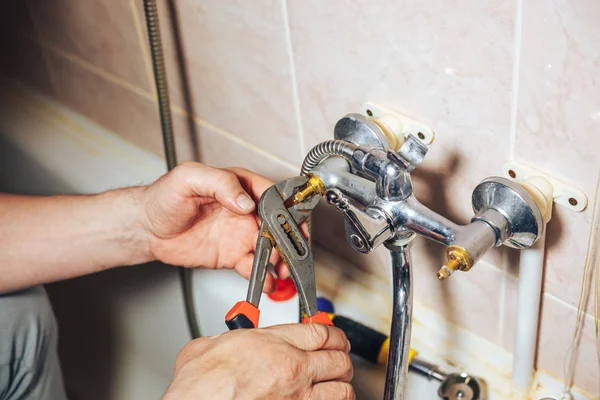 Uomo riparazione e fissaggio vecchio rubinetto che perde in bagno — Foto Stock