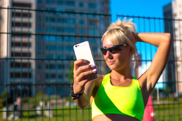 Spor sarışın kız trende Stadyumu sonra kendini telefon yapıyor — Stok fotoğraf