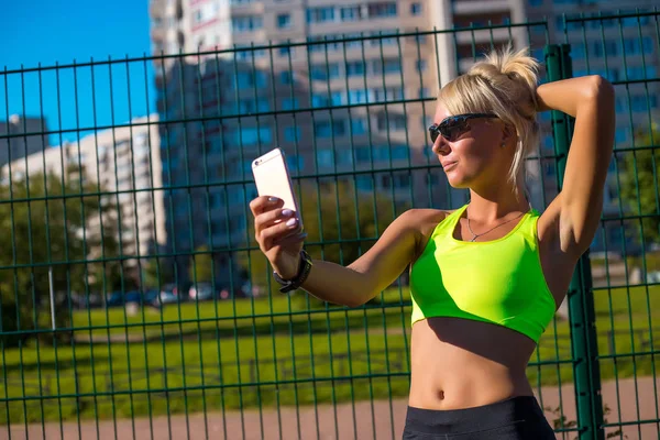 Spor sarışın kız trende Stadyumu sonra kendini telefon yapıyor — Stok fotoğraf