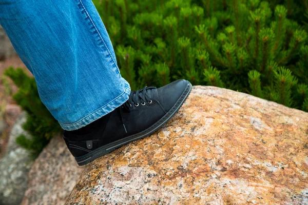 close up of feet walking step by step overcoming obstacles moving into bright future success. one person climbing over rock stones .