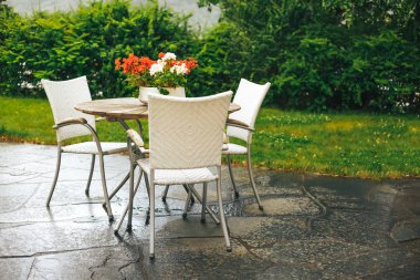 Güzel Teras ya da balkon küçük masa, sandalye ve çiçeklerle yağmur sonra