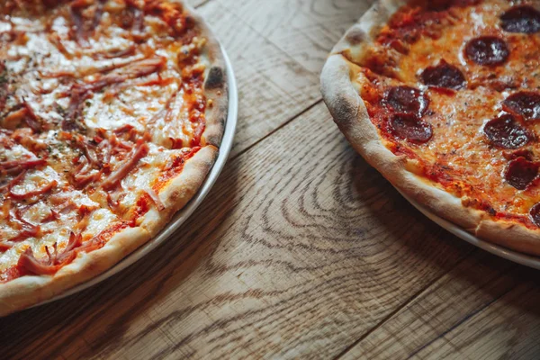 Ahşap arka plan üzerinde iki pizza