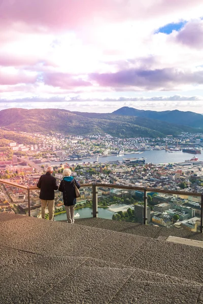elder couple on vacation looking from Top of Mount Floyen Glass Balcony Viewpoint mountain in Norway