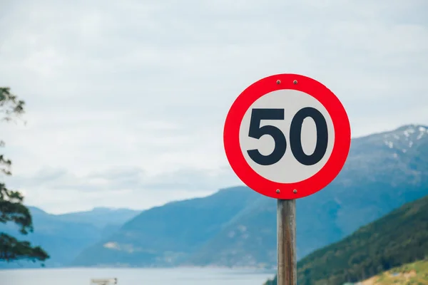 Znak drogowy limitu prędkości rundy na górskiej drodze — Zdjęcie stockowe