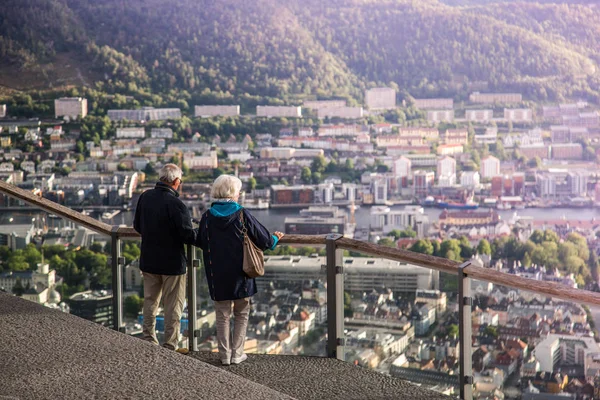 elder couple on vacation looking from Top of Mount Floyen Glass Balcony Viewpoint mountain in Norway