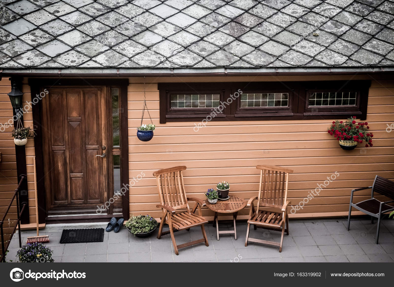 Porche del patio trasero con puerta de madera y pérgola adjunta. Vista