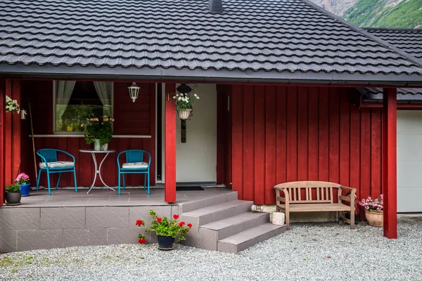Bela casa vermelha brilhante com pátio e alpendre com flores na Noruega — Fotografia de Stock