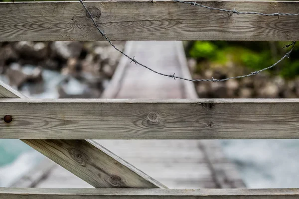 Köprünün diğer tarafında şelale önünde ahşap çit dikenli tel