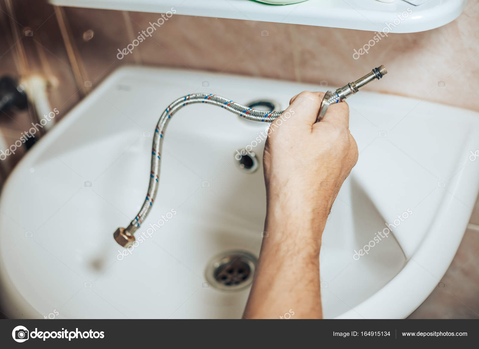 Man services and repairs leaky old faucet on the tap in the bathroom