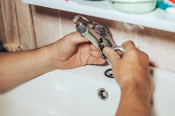 Uomo riparazione e fissaggio rubinetto nuovo che perde in bagno — Foto Stock