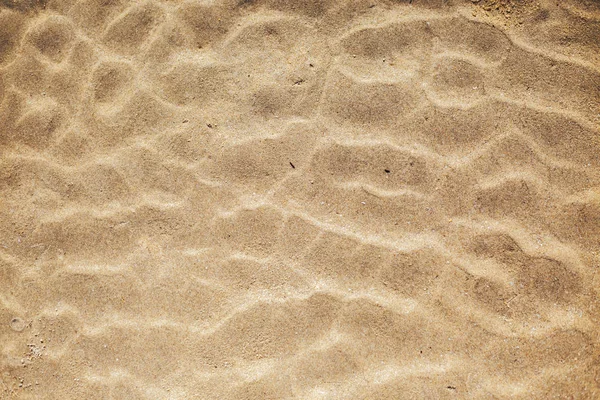 Figure sous la forme de lignes courbes dans le sable sur la plage, faire des vagues — Photo