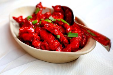 Tatlım, soya sosu, baharat ile marine edilmiş tavuk kanatları oval pişirme tavada kızartma, Asya tarifi, yukarıdan görünüm, yakın çekim için hazır ince kıyılmış maydanoz serpilir