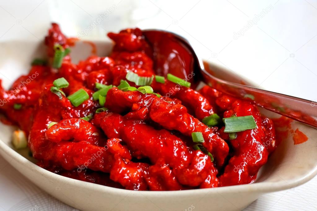 raw chicken wings marinated with honey, soy sauce,spices sprinkled with finely chopped parsley in oval baking pan prepared for roast, asian recipe, view from above, close-up