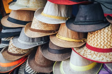 Şapka Market bambu yaprakları yapılmış. Grup Satış, bir duvarda asılı renkli şapkalar
