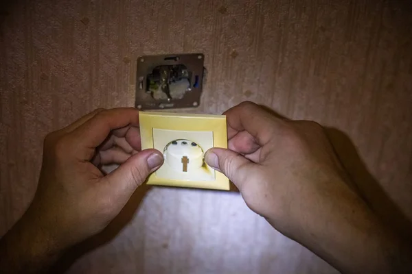 Eletricista reparando soquete na parede de luz. Instalação da tomada elétrica. O eletricista monta tomadas na instalação elétrica . — Fotografia de Stock