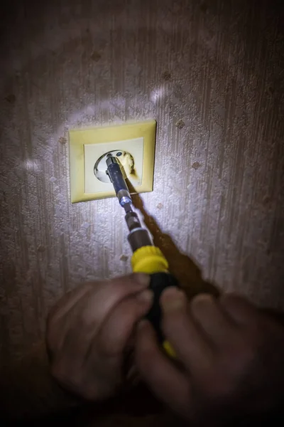 Eletricista reparando soquete na parede de luz. Instalação da tomada elétrica. O eletricista monta tomadas na instalação elétrica . — Fotografia de Stock