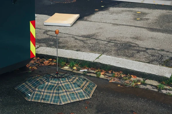 Заброшенный красный зонтик, сломанный ветром — стоковое фото