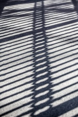 parlak güneşli bir günde. Dövme demir kapısı kaldırımda zıt gölge.