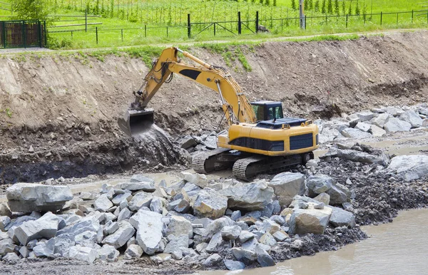 Graafmachine machine aan het werk op de bouwplaats — Stockfoto