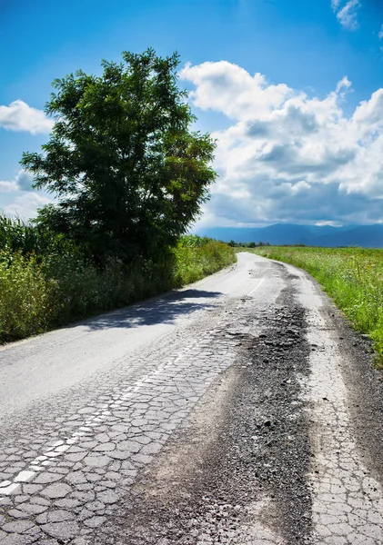 Schlechte Straße aufgebrochen und beschädigt — Stockfoto