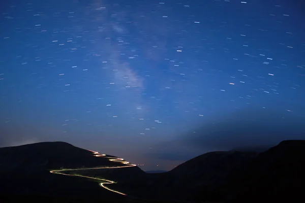 Carretera curva en las montañas de Parang, Rumania. Transalpina por la noche con senderos de coche, larga exposición . — Foto de Stock