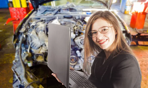 Frau mit Laptop und kaputtem Auto im Hintergrund, Auto-Service-Konzept — Stockfoto