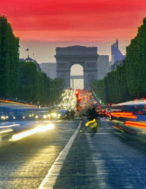 Paris şehri günbatımı sahnede. Arc de Triomphe, Champs Elysees Bulvarı yakınındaki sokak trafik uzun pozlama fotoğraf.