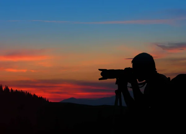 silhouette of photographer taking photos after sunset