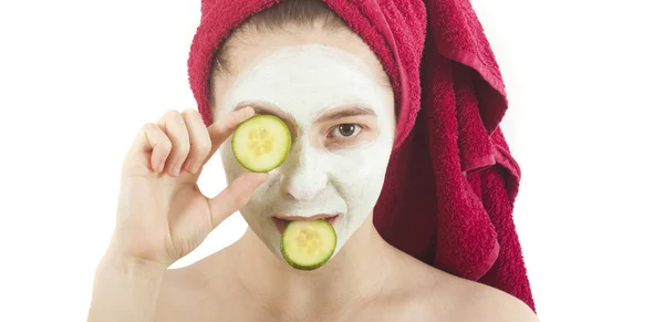 Vacker kvinna med skönhet ansikte mask i ansiktet och gurka — Stockfoto