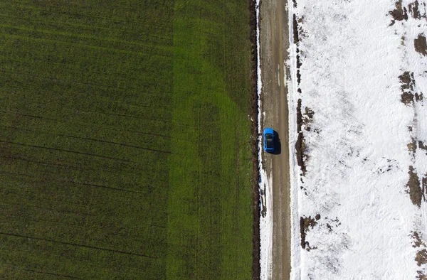 グリーン スプリング フィールドとドローンから雪の空撮 道路のシーンの車 — ストック写真
