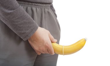 adam holding muz prezervatif ile. cinsel koruma kavramı