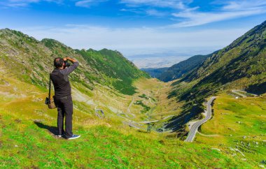 Fotoğrafçı, doğa dağ manzarasında fotoğraf çekiyor. Fagaras, Romanya