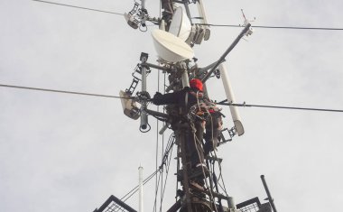 Elektrikçi ya da dağcı teftiş için direk antenine tırmanıyor.