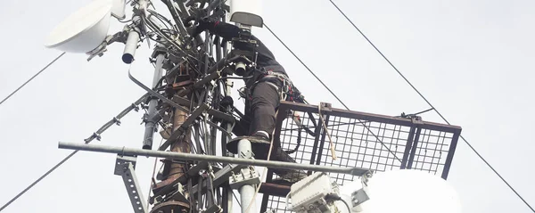 电工或登山者爬上电线杆天线检查 — 图库照片