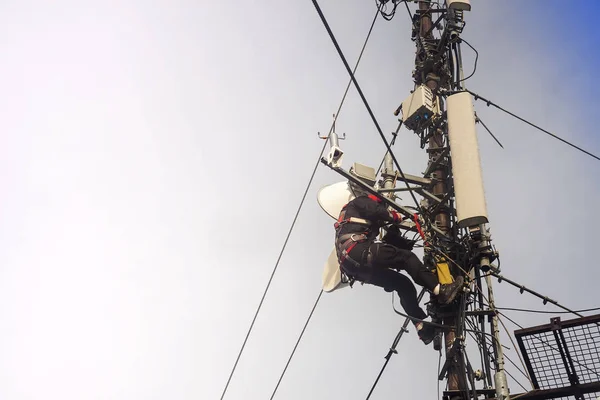 电工或登山者爬上杆子天线进行检查 — 图库照片