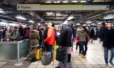 Havaalanında ya da tren yolunda bekleyen insanların bulanık bir fotoğrafı.