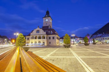 Geceleri Brasov şehri. Mavi saatte ana konsey meydanında. Romanya