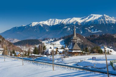 Kışın dağ manzarasında ahşap kilise. Drumul Carului, Romanya