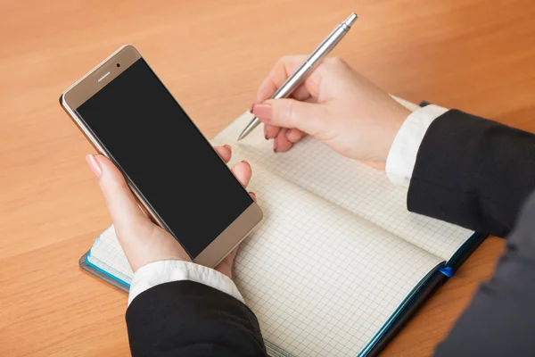 Vrouw schrijft in een notebook — Stockfoto