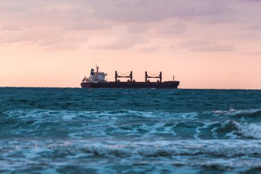 gün batımı arka plan üzerinde yüzen gemi