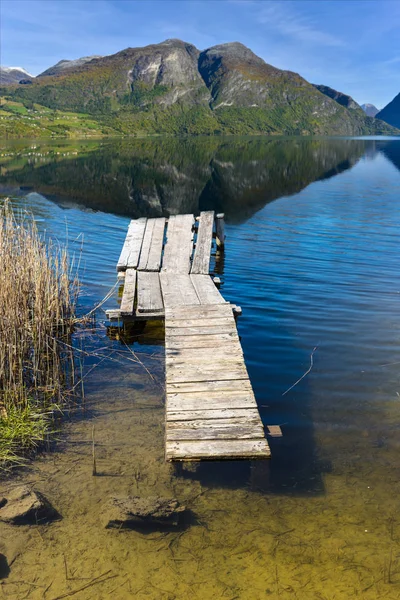 Dřevěný most na jezero v horách — Stock fotografie