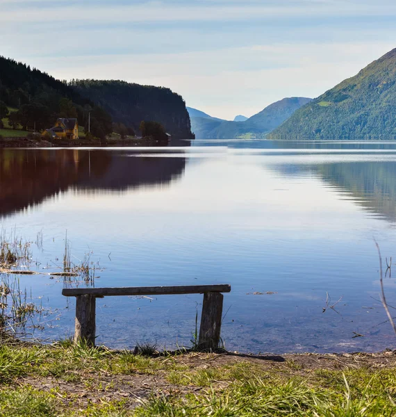 Dřevěná lavice na jezero v horách — Stock fotografie