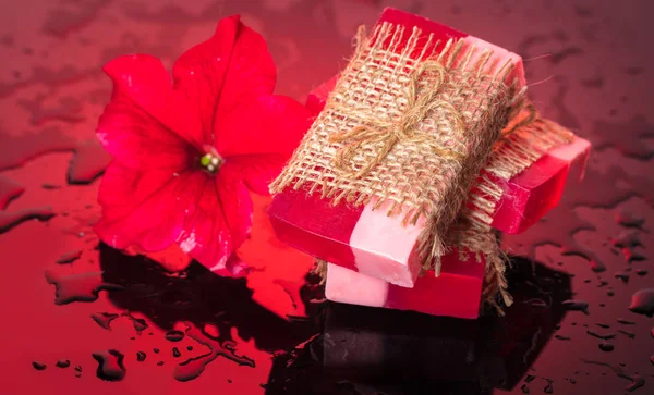 Sabão artesanal vermelho com uma flor petúnia — Fotografia de Stock