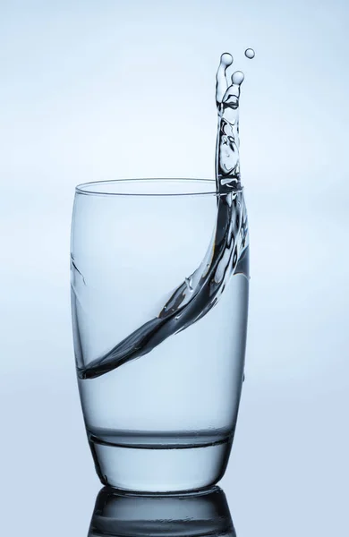 Water spatten uit een glas — Stockfoto