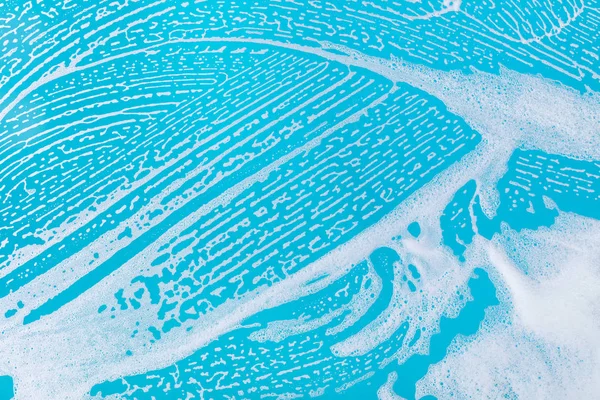 Espuma de jabón sobre un fondo azul — Foto de Stock