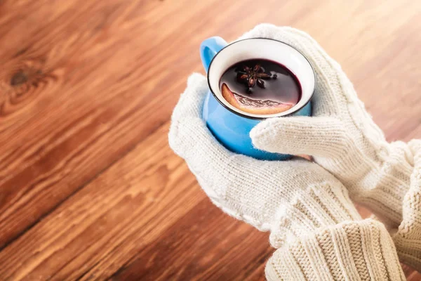 Hands in gloves holding mulled wine — Stock Photo, Image