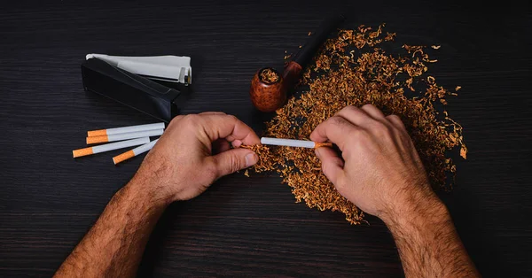 Hombre hace un cigarrillo, las manos de cerca — Foto de Stock