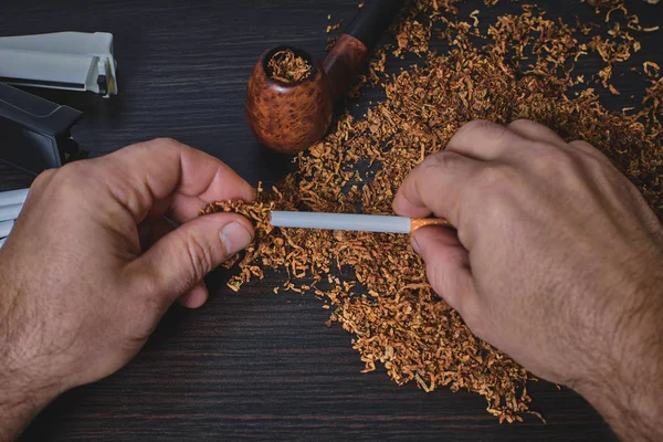 Hombre hace un cigarrillo, las manos de cerca — Foto de Stock