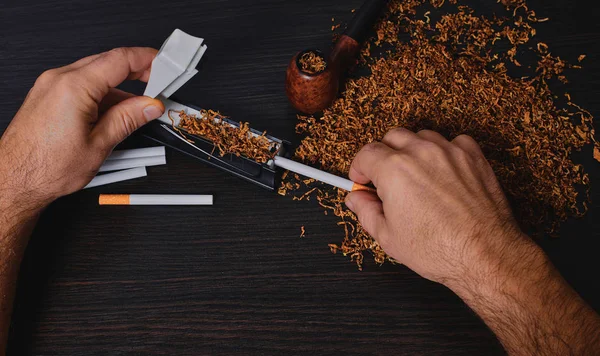 Man maakt een sigaret, handen dicht — Stockfoto